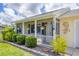 Close-up of a charming covered porch with decorative plants and welcome sign at 1778 N Salford Blvd, North Port, FL 34286