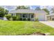 Charming single-story home with a well-manicured lawn and cozy front porch featuring hanging flower baskets at 1778 N Salford Blvd, North Port, FL 34286