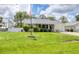 Inviting single-story home with lush green lawn, American flag, and welcoming front porch at 1778 N Salford Blvd, North Port, FL 34286