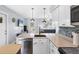 Modern kitchen featuring white cabinets, stainless steel appliances, and an open layout to the living areas at 1778 N Salford Blvd, North Port, FL 34286