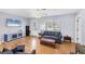 Bright living room with hardwood floors, a ceiling fan, and a comfortable blue sofa at 1778 N Salford Blvd, North Port, FL 34286