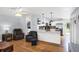 Open-concept living room with hardwood floors flowing into the kitchen with pendant lighting and stainless steel appliances at 1778 N Salford Blvd, North Port, FL 34286