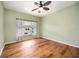 Bright bedroom features wood floors, neutral paint, ceiling fan, and window with privacy blinds at 1801 Highland Rd, Osprey, FL 34229