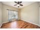 Neutral bedroom features wood floors, a ceiling fan and a large window with privacy blinds at 1801 Highland Rd, Osprey, FL 34229
