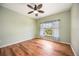 Bright and airy bedroom featuring wood floors, a ceiling fan, and a large window with natural light at 1801 Highland Rd, Osprey, FL 34229