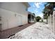 Exterior side of home with white door leading to covered porch and stone landscaping at 1801 Highland Rd, Osprey, FL 34229