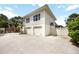 Beige two-story home with two-car garage, crushed gravel driveway and tropical landscaping at 1801 Highland Rd, Osprey, FL 34229