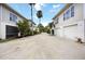Wide shot of crushed gravel road leading to two-story homes and tropical landscaping at 1801 Highland Rd, Osprey, FL 34229