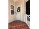 Inviting front door with a wreath, complemented by stylish tiled steps and neutral siding at 1801 Highland Rd, Osprey, FL 34229