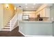 Open kitchen and dining area with granite countertops, stainless appliances, and a staircase leading to the second floor at 1801 Highland Rd, Osprey, FL 34229