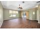 Spacious living room with wood tile flooring, tray ceiling, large windows, and sliding glass doors to screened porch at 1801 Highland Rd, Osprey, FL 34229