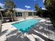Backyard view of a beautiful private pool surrounded by lush tropical landscaping and deck seating at 1801 Highland Rd, Osprey, FL 34229