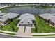 Aerial view showcasing a waterfront home with a manicured lawn, paved driveway, and stunning lake views at 18039 Cherished Loop, Bradenton, FL 34211