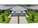 Aerial view of a home with manicured lawn, paved driveway, and waterfront backyard with lake views at 18039 Cherished Loop, Bradenton, FL 34211