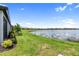 Serene backyard view of a lake with lush green grass and neighboring houses in the distance at 18039 Cherished Loop, Bradenton, FL 34211