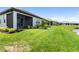 Expansive backyard with a well-maintained lawn, screened lanai, and peaceful water views at 18039 Cherished Loop, Bradenton, FL 34211
