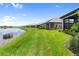 Waterfront backyard featuring lush green grass and a serene lake view, perfect for outdoor enjoyment at 18039 Cherished Loop, Bradenton, FL 34211