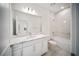 A bright bathroom featuring white cabinets, quartz countertops, and tiled walls with a tub-shower combination at 18039 Cherished Loop, Bradenton, FL 34211
