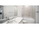 Bright bathroom featuring white cabinets, quartz countertops, and tiled walls with a tub-shower combination at 18039 Cherished Loop, Bradenton, FL 34211