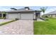 Beautiful paired villas with brick driveways, well-manicured lawns, and modern gray exteriors provide exceptional curb appeal at 18039 Cherished Loop, Bradenton, FL 34211