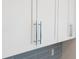 Close-up of kitchen cabinets with sleek, silver handles and a gray tile backsplash at 18039 Cherished Loop, Bradenton, FL 34211