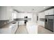 Bright kitchen features white cabinetry, stainless steel appliances, and large island with marble countertops at 18039 Cherished Loop, Bradenton, FL 34211