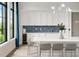 Modern kitchen with white cabinets, stylish backsplash, and island seating at 18039 Cherished Loop, Bradenton, FL 34211