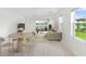 Bright living room and dining area with neutral decor, tile floors, and large windows with a water view at 18039 Cherished Loop, Bradenton, FL 34211