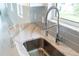 Close-up on a stainless steel kitchen sink with a modern faucet and granite countertop at 18039 Cherished Loop, Bradenton, FL 34211