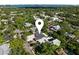 Aerial view of a single-story home with lush green surroundings, modern architecture, and a location marker at 1881 Orchid St, Sarasota, FL 34239