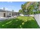 Lush backyard with green lawn, screened-in patio, and privacy fence at 1881 Orchid St, Sarasota, FL 34239