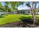 Expansive backyard featuring lush green lawn, white fence, screened-in porch, and mature landscaping at 1881 Orchid St, Sarasota, FL 34239