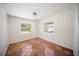 A cozy bedroom with terra cotta tile flooring, windows, and a modern ceiling light at 1881 Orchid St, Sarasota, FL 34239