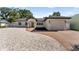 Charming single story home featuring a brick driveway, manicured landscaping, and attached garage at 1881 Orchid St, Sarasota, FL 34239