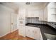 Cozy kitchen with white cabinets, granite countertops, and unique backsplash tiling at 1881 Orchid St, Sarasota, FL 34239
