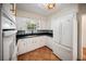 Charming kitchen with white cabinets, black countertops, and vibrant, patterned backsplash at 1881 Orchid St, Sarasota, FL 34239