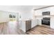 Bright, open kitchen featuring white cabinets, stainless steel appliances, and a breakfast bar with ample counter space at 1922 Cobb Trl, Parrish, FL 34219