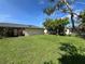 Large backyard with green grass and tropical trees at 19358 Edgewater Dr, Port Charlotte, FL 33948