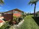 Lush backyard featuring a well-maintained lawn, mature landscaping, and an enclosed porch at 19358 Edgewater Dr, Port Charlotte, FL 33948