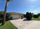 View of the home's exterior, showcasing the two-car garage and manicured landscaping against a clear blue sky at 19358 Edgewater Dr, Port Charlotte, FL 33948
