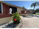 View of the front entrance featuring privacy panel, lush foliage, and meticulous rock landscaping with a decorative lion statue at 19358 Edgewater Dr, Port Charlotte, FL 33948