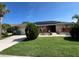 Inviting single-story home showcasing solar panels and a lush, green lawn under a bright, clear blue sky at 19358 Edgewater Dr, Port Charlotte, FL 33948