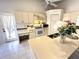 Bright kitchen featuring white appliances, tiled floors, neutral cabinetry, and a ceiling fan at 19358 Edgewater Dr, Port Charlotte, FL 33948
