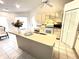 Bright kitchen featuring white appliances, tiled floors, neutral cabinetry, and a central island at 19358 Edgewater Dr, Port Charlotte, FL 33948