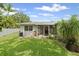 Picture of a green backyard with screened-in porch, lush lawn, and tropical plants at 2115 9Th W Ave # 3D, Bradenton, FL 34205