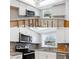 Split image showing before and after of newly renovated kitchen with grey backsplash and stainless steel appliances at 2115 9Th W Ave # 3D, Bradenton, FL 34205