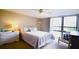 Cozy bedroom featuring a queen-size bed, nightstand, and a sliding glass door at 21405 Olean Blvd # 224, Port Charlotte, FL 33952