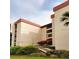 Exterior angle shot of a condominium building with manicured lawn and sidewalks at 21405 Olean Blvd # 224, Port Charlotte, FL 33952