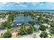 Aerial view of a waterfront property in a residential neighborhood with a lake and lush greenery at 220 39Th Ne St, Bradenton, FL 34208