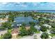 Aerial view of a waterfront property in a residential neighborhood with a lake and lush greenery at 220 39Th Ne St, Bradenton, FL 34208